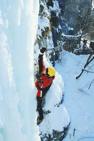 Eisklettern im Nordkaukasus, Mann besteigt gefrorenen Wasserfall. — Stockfoto