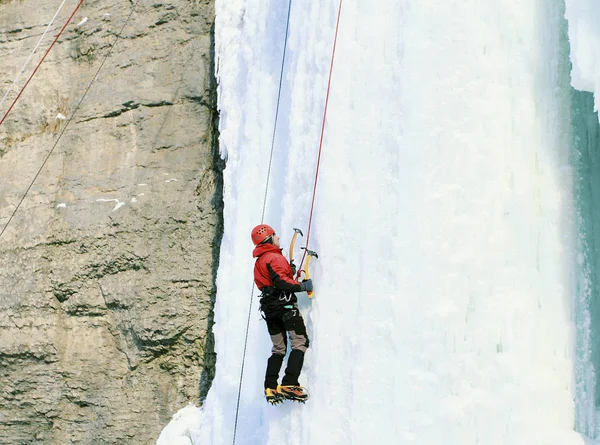 アイス クライミング北コーカサス、凍った滝を登る男. — ストック写真