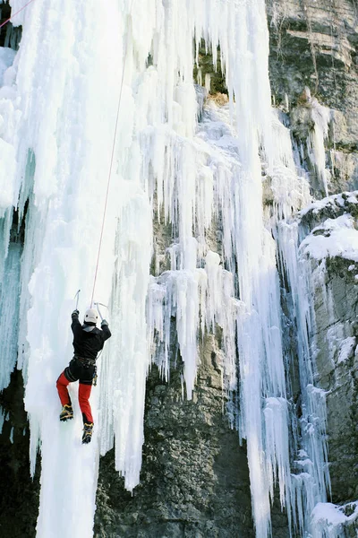 Ice climbing the North Caucasus, man climbing frozen waterfall.