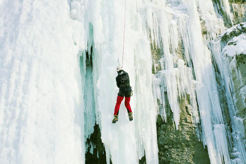 Ice climbing the North Caucasus, man climbing frozen waterfall.