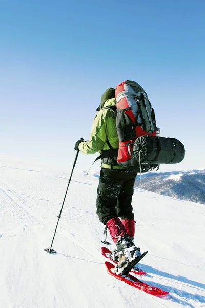 Caminhada de inverno nas montanhas com uma mochila e tenda . — Fotografia de Stock