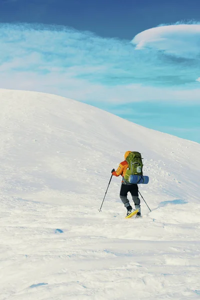 Winter hike in the mountains with a backpack and tent. — Stock Photo, Image