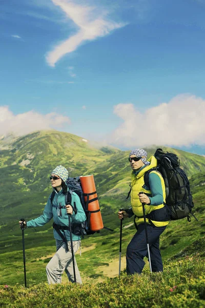 Summer hike in the mountains, a guy and a girl are walking along — Stock Photo, Image