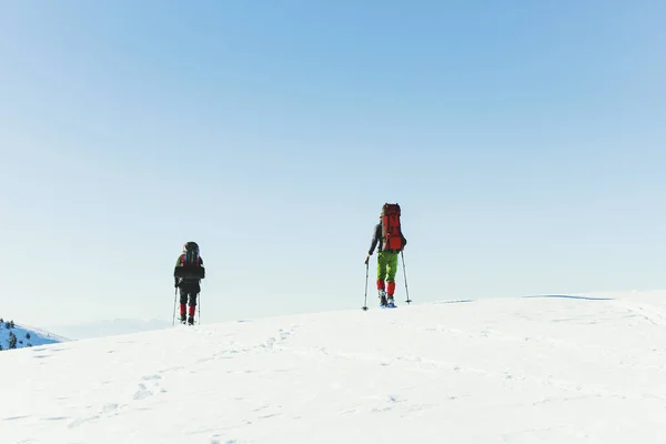 Téli túra a hegyekben, két ember sétál végig a hó — Stock Fotó