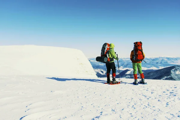 Χειμερινή πεζοπορία στα βουνά, δύο άνδρες είναι το περπάτημα στο χιόνι — Φωτογραφία Αρχείου