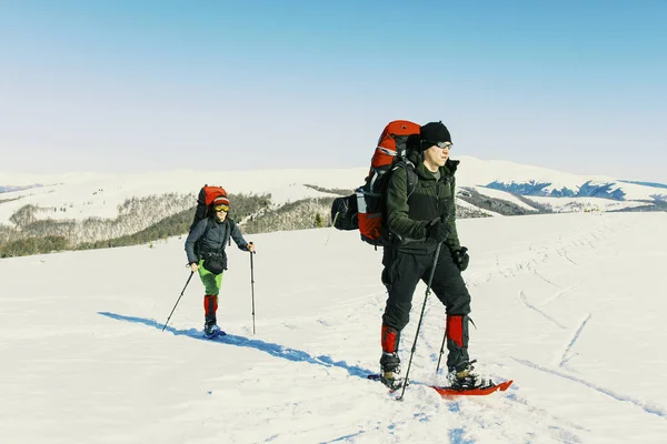 Kış dağlarda yürüyüş, iki adam kar yürüyor — Stok fotoğraf