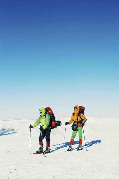 Caminata de invierno en las montañas, dos hombres están caminando por la nieve — Foto de Stock