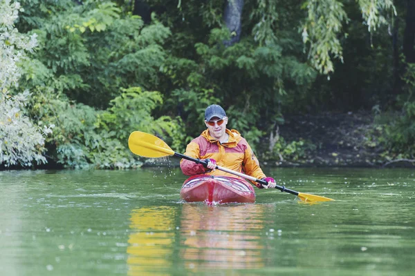 Canoagem. Um homem está remando ao longo do rio . — Fotografia de Stock