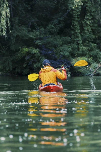 Canoagem. Um homem está remando ao longo do rio . — Fotografia de Stock