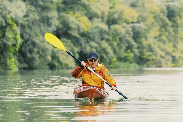 Canoagem. Um homem está remando ao longo do rio . — Fotografia de Stock