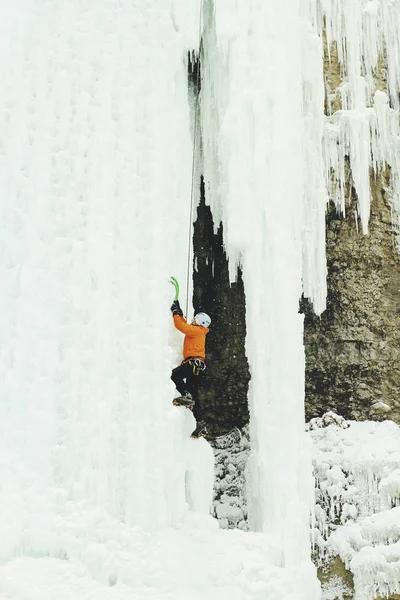 Escalada de gelo no norte do Cáucaso. Um homem sobe o waterfal — Fotografia de Stock