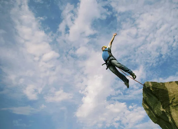 A man is jumping from a cliff to an abyss. — Stock Photo, Image