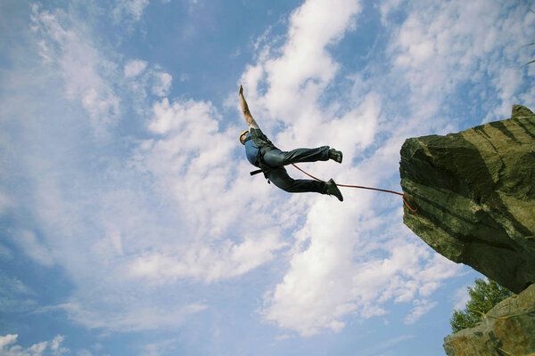 Человек прыгает со скалы в пропасть.
.