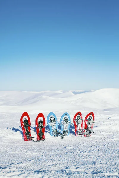 Trekking de inverno nas montanhas. Sapatilhas de neve ficar no ag neve — Fotografia de Stock