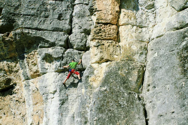 Escalada en roca. Un hombre sube a las rocas . — Foto de Stock