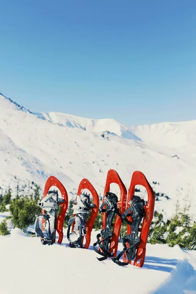 Trekking de inverno nas montanhas. Sapatilhas de neve ficar no ag neve — Fotografia de Stock