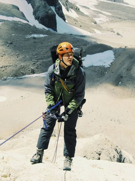 Der Bergsteiger schafft den Aufstieg auf den Gipfel des Berges. — Stockfoto