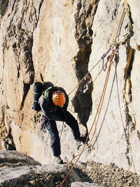 De klimmer klimt naar de top van de berg. — Stockfoto