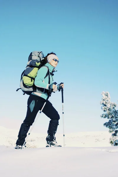 Caminata de invierno en las montañas con una mochila y tienda de campaña . — Foto de Stock