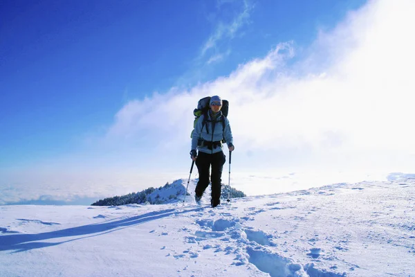 Winter hike in the mountains with a backpack and tent. — Stock Photo, Image