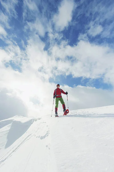 Vintern vandra i bergen på snöskor med en ryggsäck och — Stockfoto