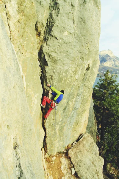 Bergsteiger, der eine herausfordernde Klippe erklimmt. Extremsport klettert — Stockfoto