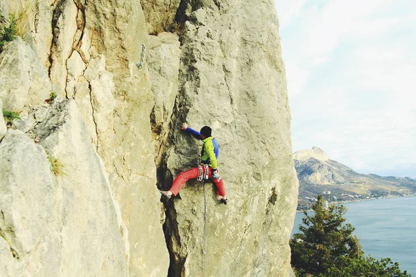 Scalatore di roccia che sale su una falesia impegnativa. Climbi sport estremi — Foto Stock
