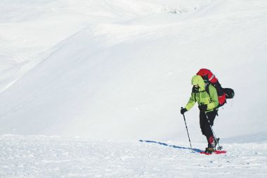 Bir sırt çantası ve çadır ile dağlarda kış yürüyüş.