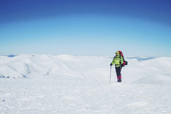 Caminhada de inverno nas montanhas com uma mochila e tenda . — Fotografia de Stock