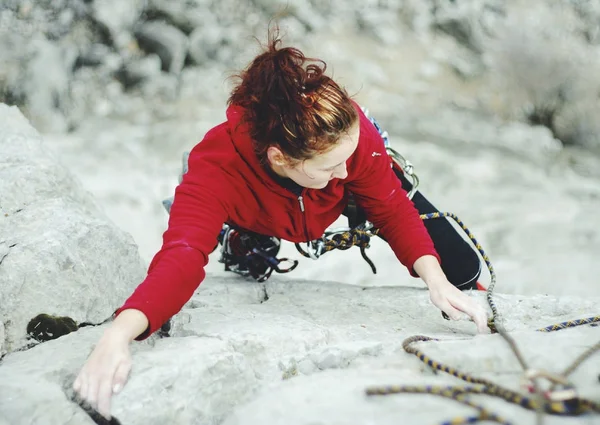 一个年轻女子用绳子从事攀岩运动 — 图库照片