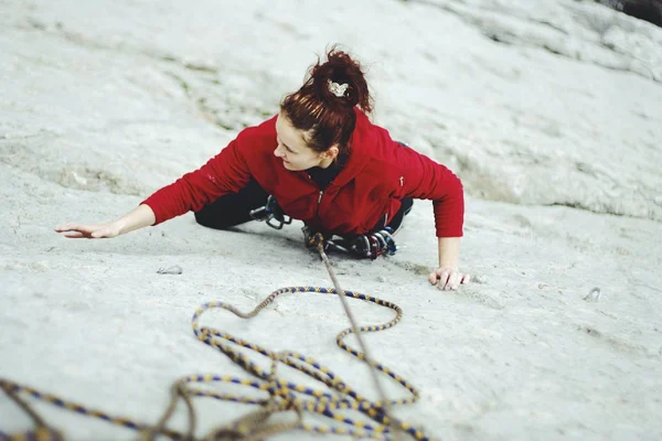 Μια νεαρή γυναίκα με ένα σχοινί που ασχολούνται με το σπορ της αναρρίχησης βράχου — Φωτογραφία Αρχείου