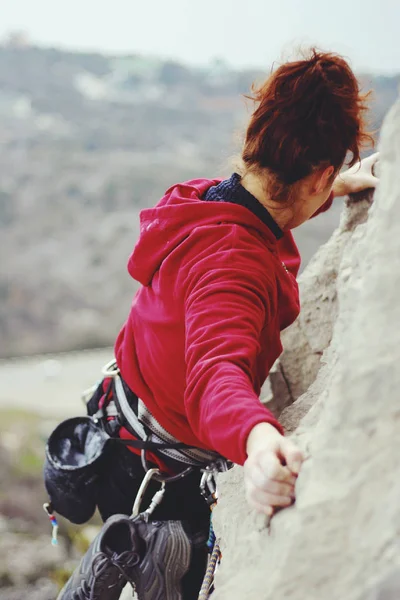 Een jonge vrouw met een touw die zich bezighouden met de sport van rotsklimmen — Stockfoto