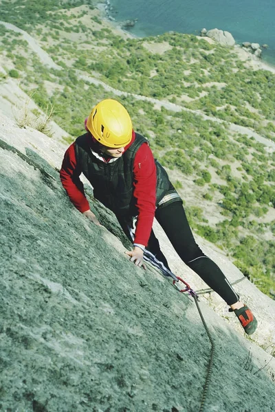 Uma jovem mulher com uma corda envolvida nos esportes de escalada — Fotografia de Stock