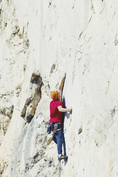 Alpinista subindo um penhasco desafiador. Escalada desportiva extrema — Fotografia de Stock