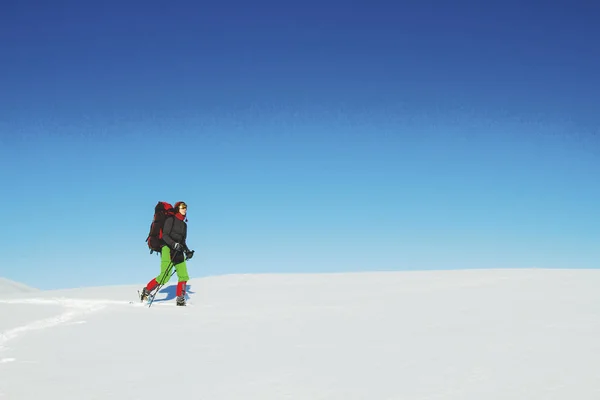 Schneeschuhwanderer läuft im Pulverschnee bei schönem Sonnenaufgang — Stockfoto