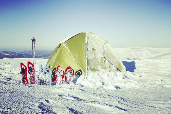 Caminhadas de inverno nas montanhas em sapatos de neve com uma mochila e — Fotografia de Stock