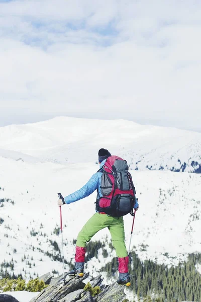 Turista v zimních horách. Muž s batohem trekking v horsk — Stock fotografie