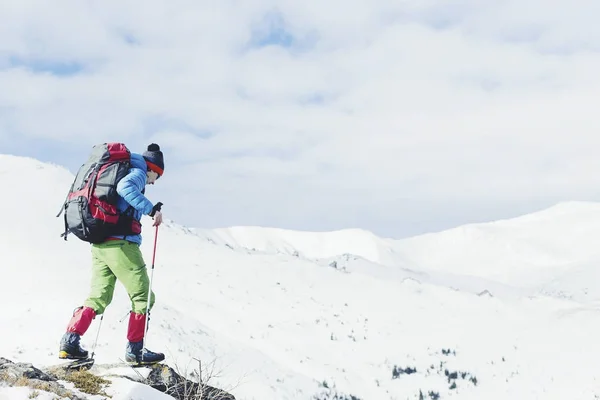 Caminante en las montañas de invierno. Hombre con mochila trekking en mountai — Foto de Stock