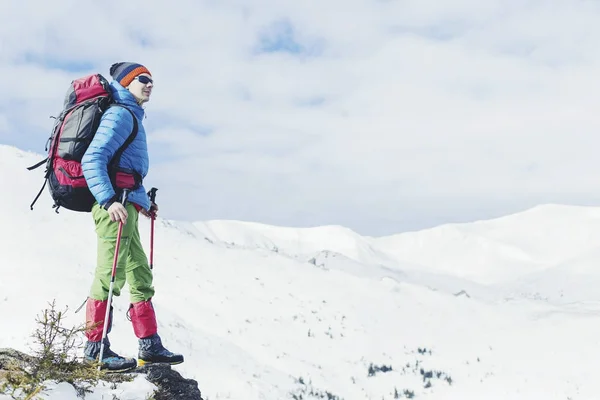 Caminhante nas montanhas de inverno. Homem com mochila trekking em mountai — Fotografia de Stock