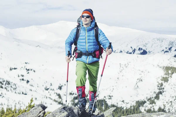 冬の山のハイカー。山でトレッキングのバックパックを持つ男 — ストック写真