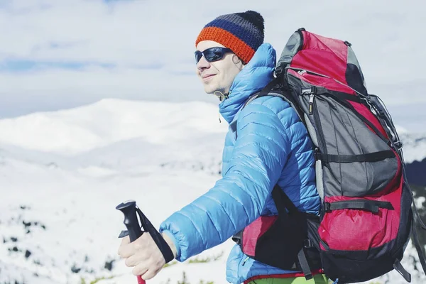 Caminante en las montañas de invierno. Hombre con mochila trekking en mountai — Foto de Stock
