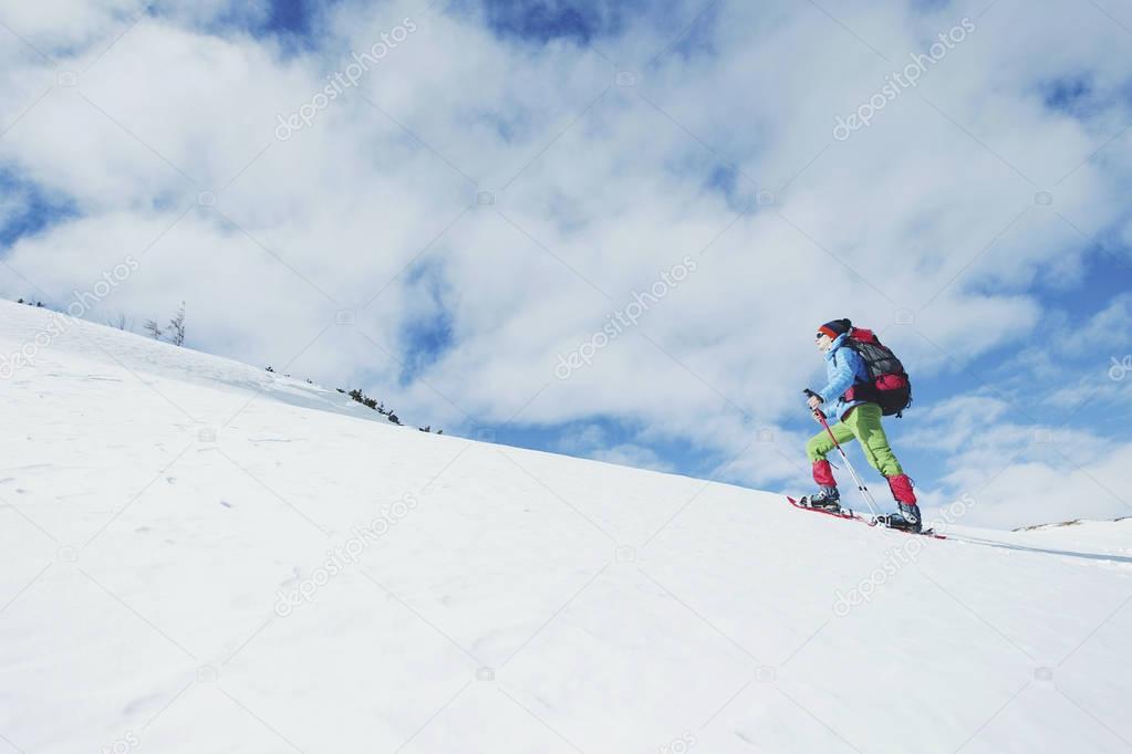 Hiker in winter mountains. Man with backpack trekking in mountai