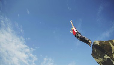 Bir adam bir kanyona bir uçurumdan atlar..