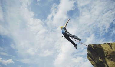 Bir adam bir kanyona bir uçurumdan atlar..