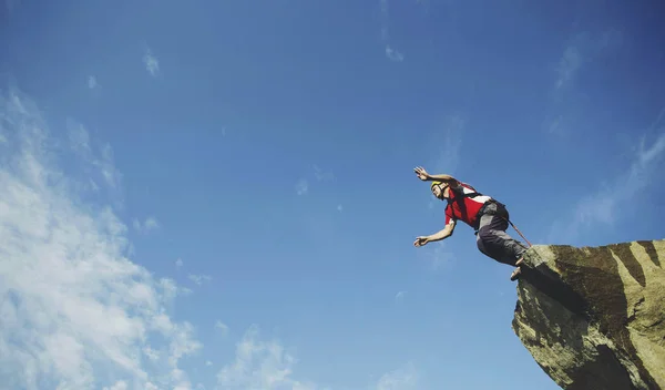 Een man springt in een canyon van een klif. — Stockfoto