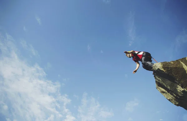 Um homem salta para um desfiladeiro de um penhasco . — Fotografia de Stock