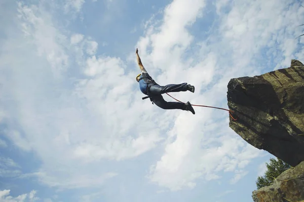 Um homem salta para um desfiladeiro de um penhasco . — Fotografia de Stock