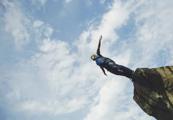 A man jumps into a canyon from a cliff. — Stock Photo, Image