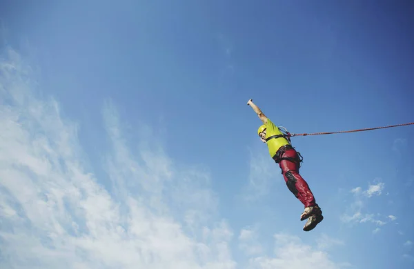 A man jumps into a canyon from a cliff. — Stock Photo, Image