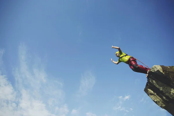 Ein Mann springt von einer Klippe in eine Schlucht. — Stockfoto